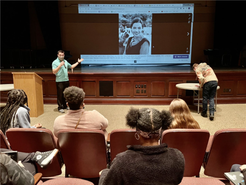 Photo shows backs of students sitting in auditorium listening to Mr. TeCulver speak about A Movement for Rosa